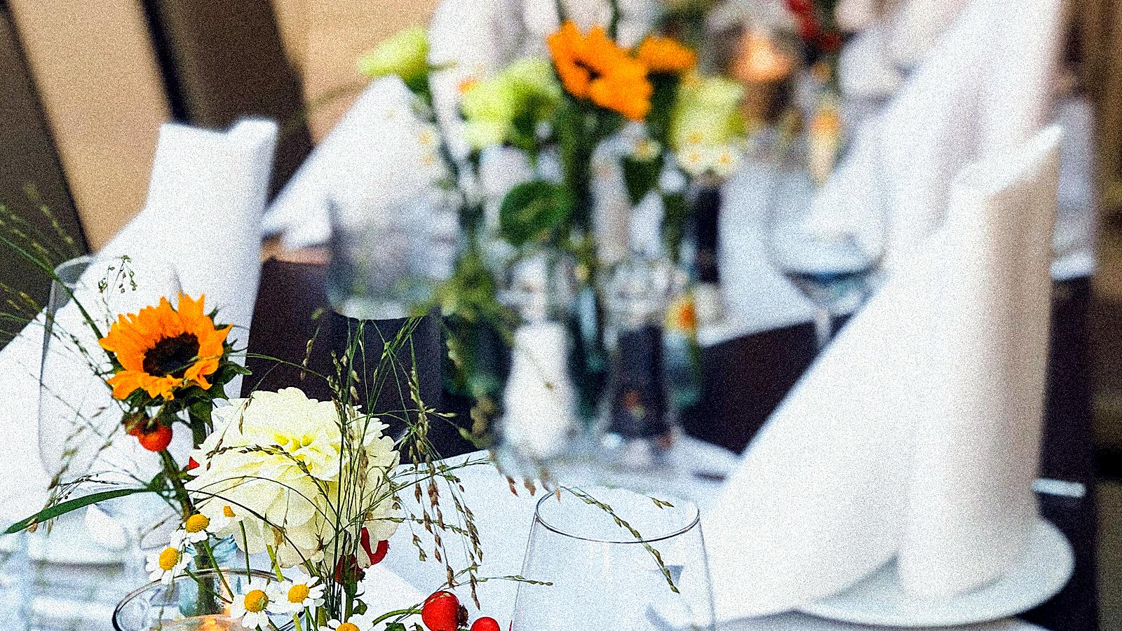 Festlich gedeckte Tafel mit Sonnenblumen und Kerzenlicht